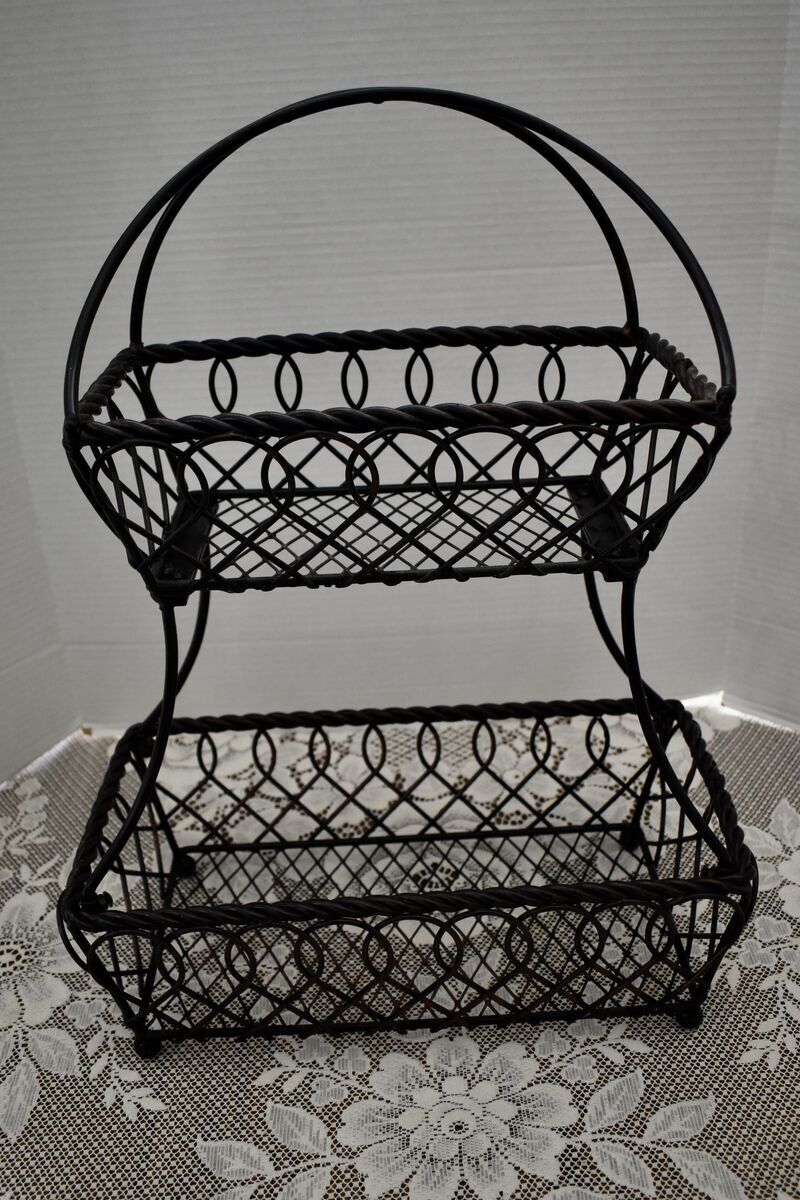 A Large Decorative Two Tiered Metal Basket For Holding Fruits, Veggies, Pastries And More