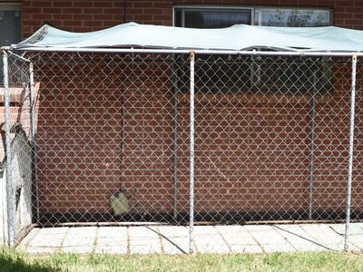 Dog kennel with attached dog house