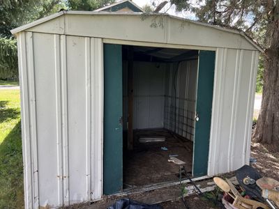Used Metal Outdoor Storage Shed. Steel. Damaged roof.