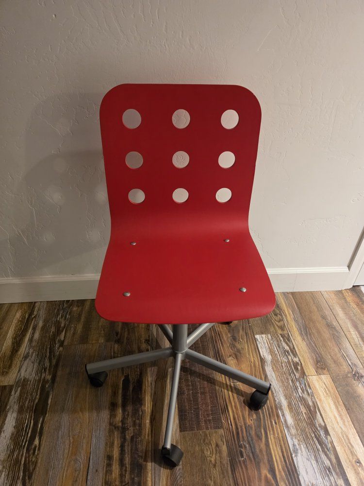 Swivel chair with a perforated backrest and silver metal