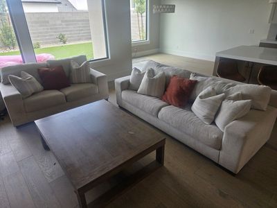 Creamy Beige Sofa and Loveseat Set with Red and Patterned Throw Pillows