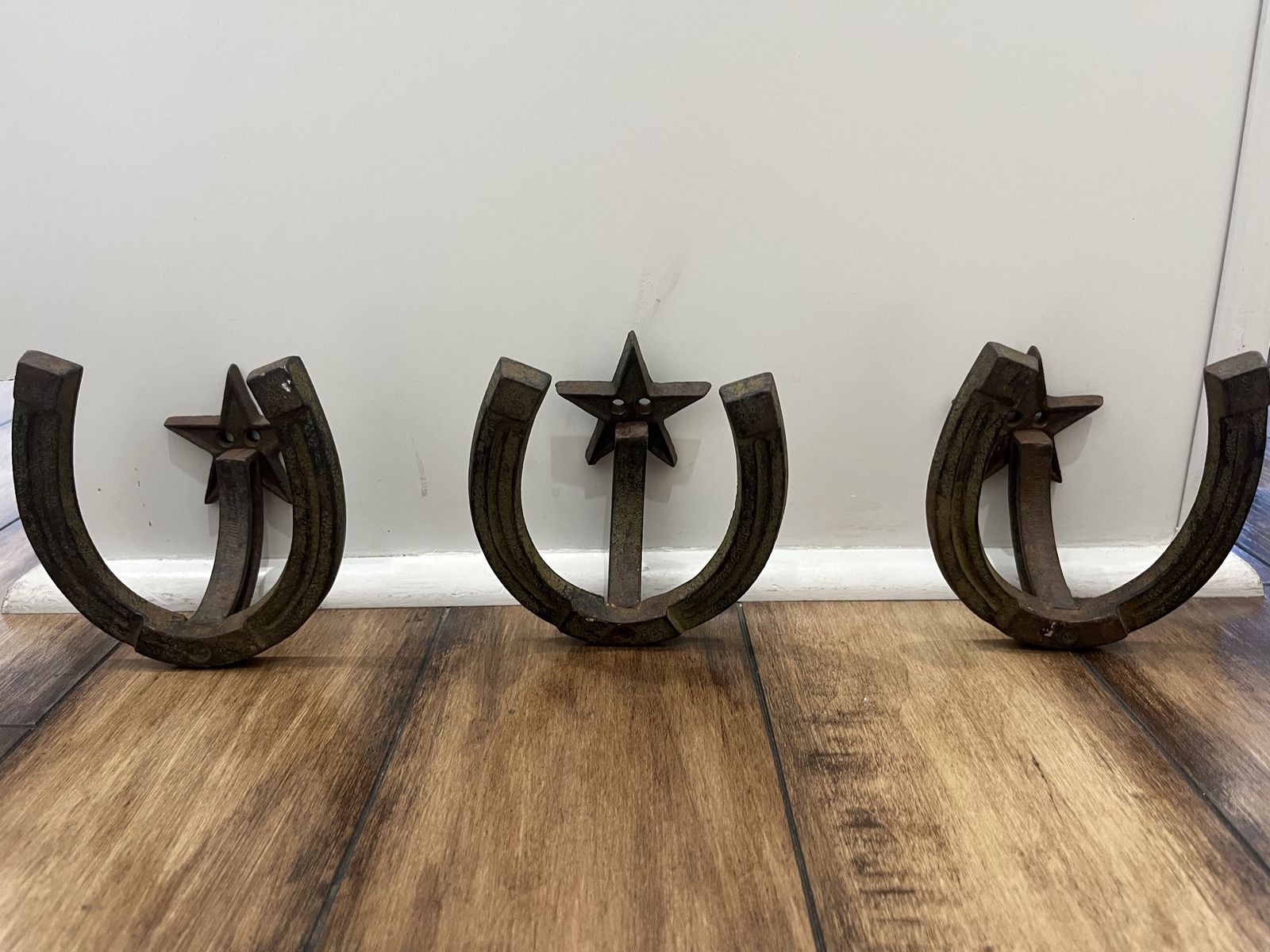 Three rustic western horseshoe coat racks.
