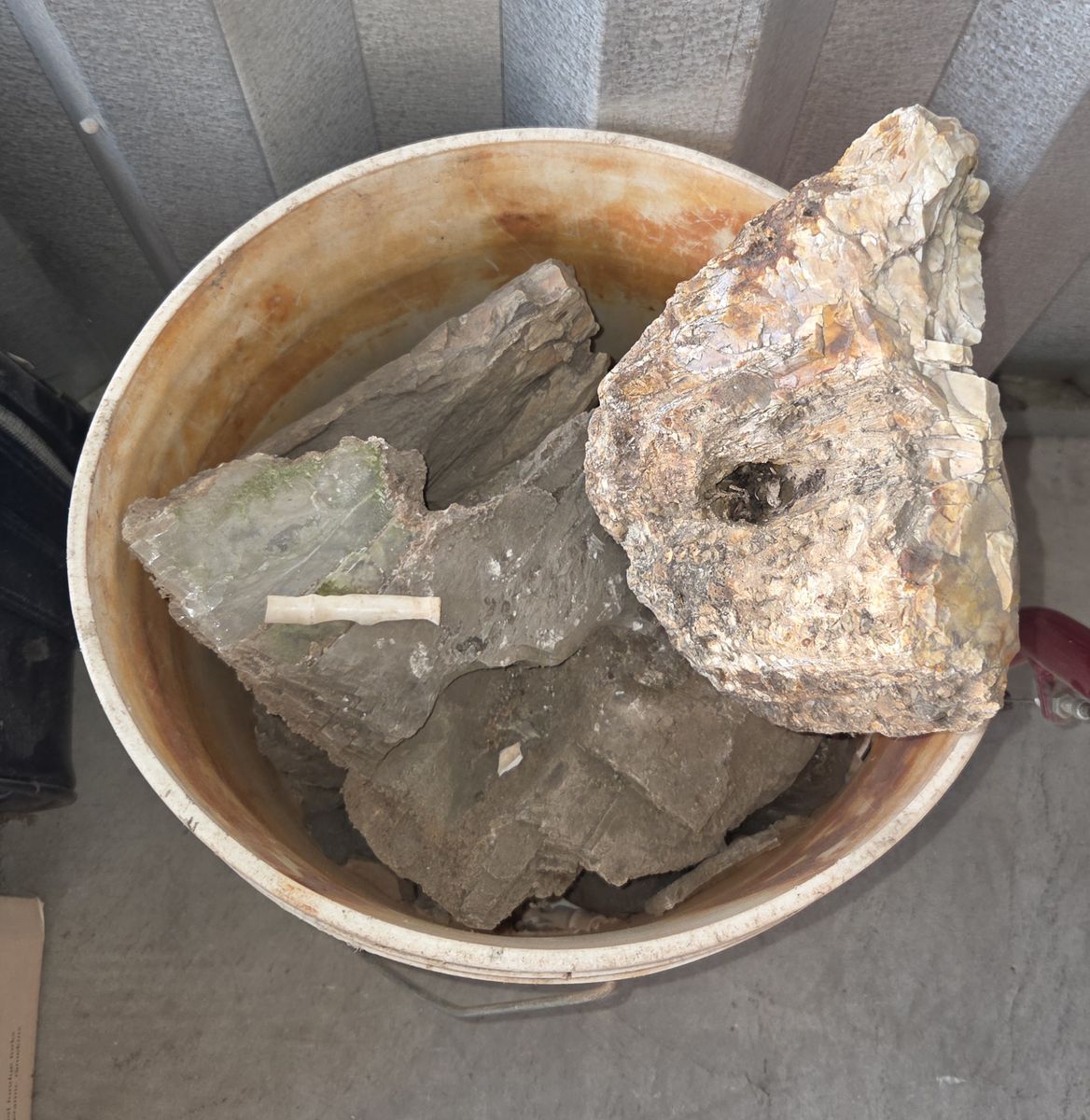Assorted large rocks in bucket & another in a crate