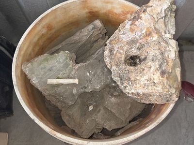 Assorted large rocks in bucket & another in a crate