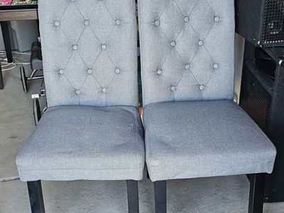 Gray fabric, upholstered tufted dining chairs with Black Legs. Been a little beat up, but still work.