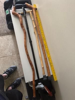 two wooden canes, one adjustable aluminum cane, and a yardstick.