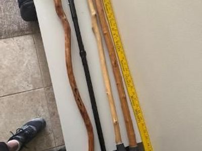 two wooden canes, one adjustable aluminum cane, and a yardstick.