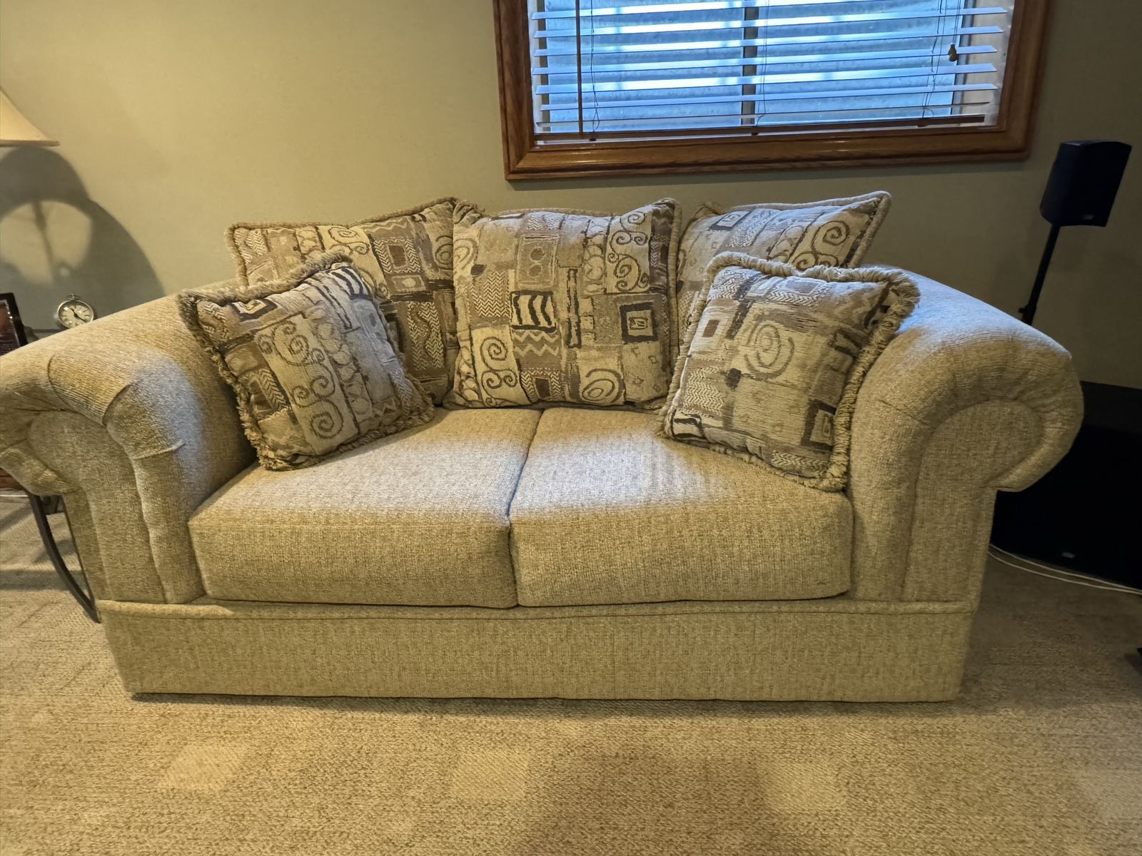 Upholstered Beige Fabric Couch with Matching Patterned Accent Pillows and matching loveseat.
