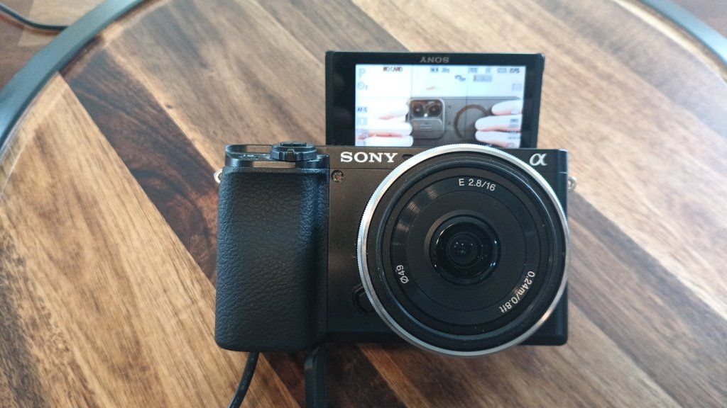 Sony Alpha a6100 Mirrorless Digital Camera. Mini shotgun mic, bag, and Sony 16mm f/2.8 pancake lens. Battery and wired power