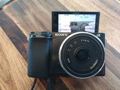 Sony Alpha a6100 Mirrorless Digital Camera. Mini shotgun mic, bag, and Sony 16mm f/2.8 pancake lens. Battery and wired power