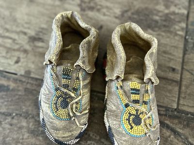 Decorative beaded moccasin figurines with faux suede finish and colorful beadwork.