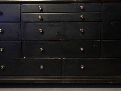 Black Wooden Dresser with Multiple Drawers and Decorative Knobs