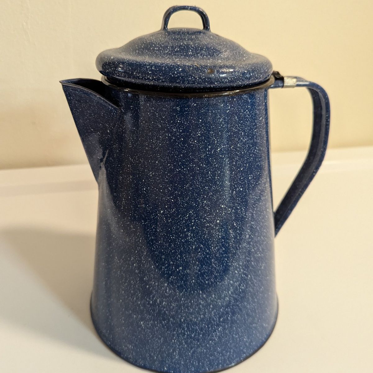 blue and white speckled enamelware coffee pot