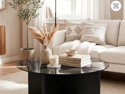 Modern Round Glass Coffee Table with brown legs.