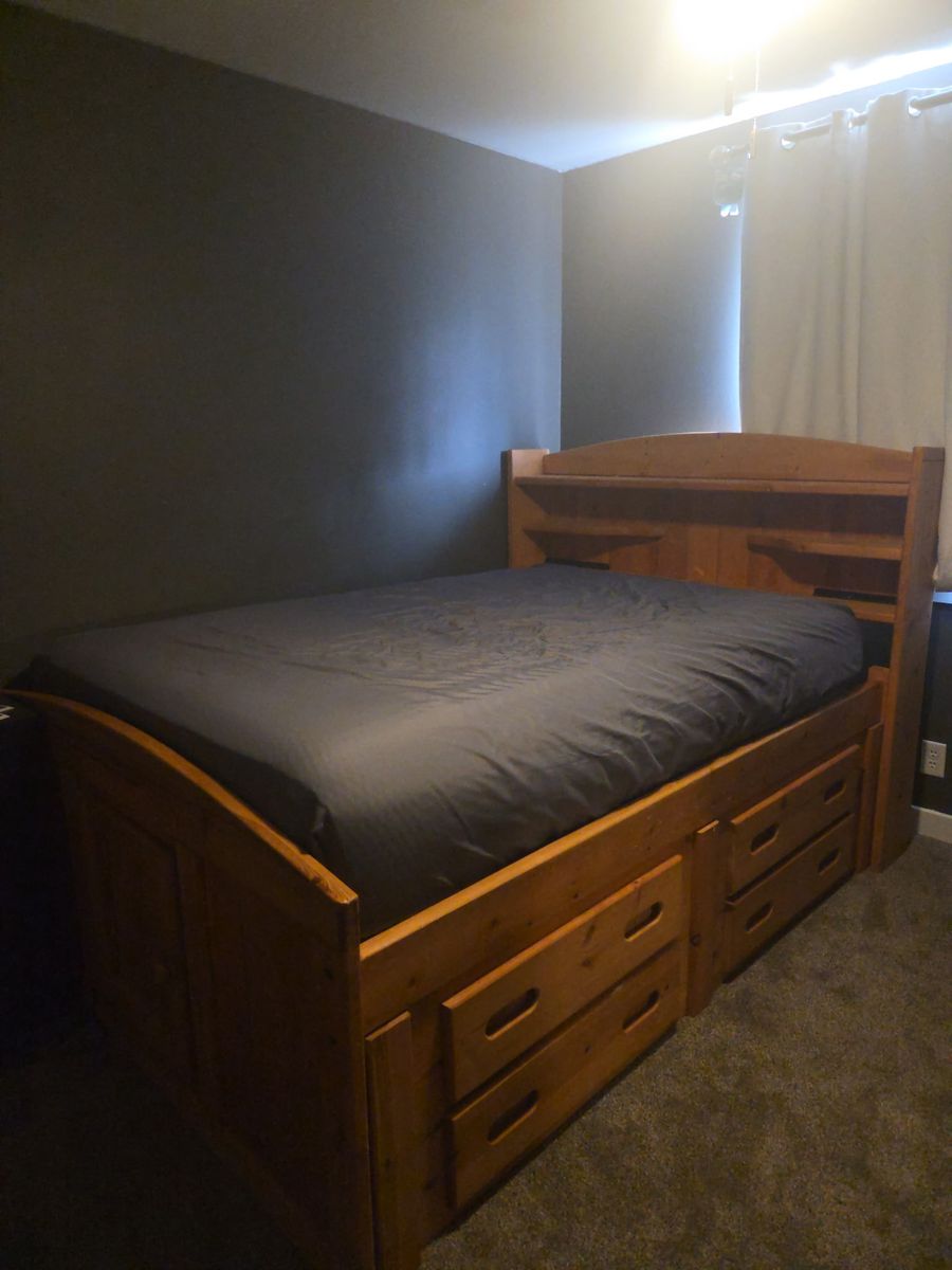 Full-size bed mattress with frame and drawers at bottom