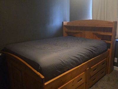 Full-size bed mattress with frame and drawers at bottom