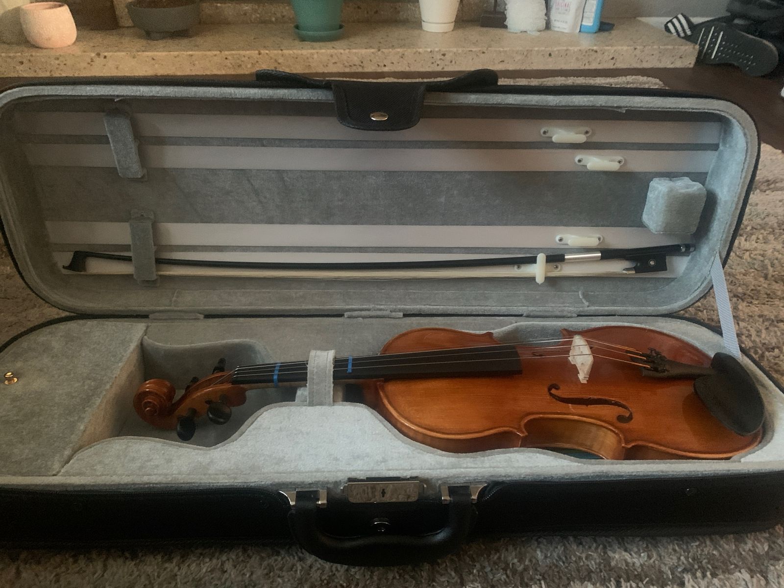 3/4 size violin with a shoulder rest, rosin, foldable music stand, and a metronome/tuner.