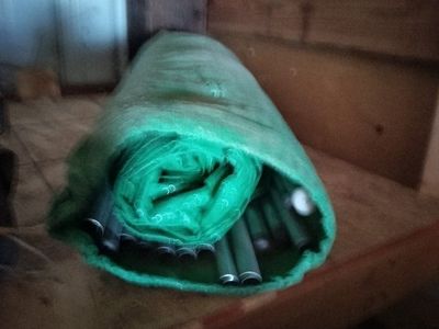 Used Rolled Green Tent with Metal Poles and Protective Cover