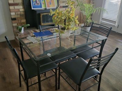 Modern Glass Top Dining Table with Four Black Metal Chairs