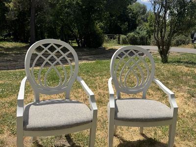Two classic sturdy white chairs with cushions
