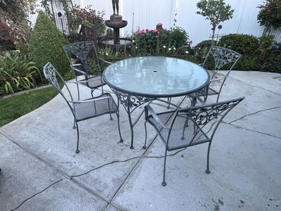 Solid all metal vintage patio set with glass top and umbrella holes.