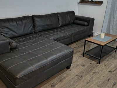 Used Dark Gray Sectional Sofa with Left-Hand Facing Chaise and White Stitching