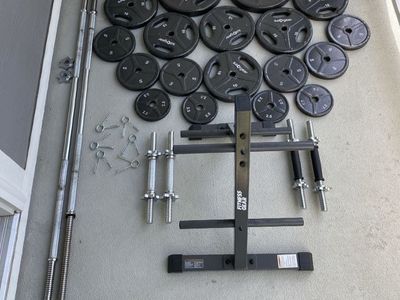1inch weight plates with bars, dumbbell handles, and storage rack