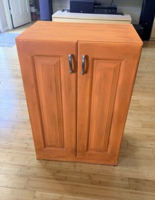 Solid wood storage cabinet with two doors and a pull-out drawer.