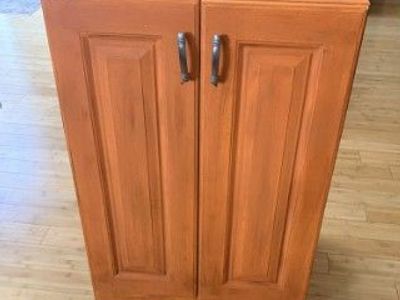 Solid wood storage cabinet with two doors and a pull-out drawer.
