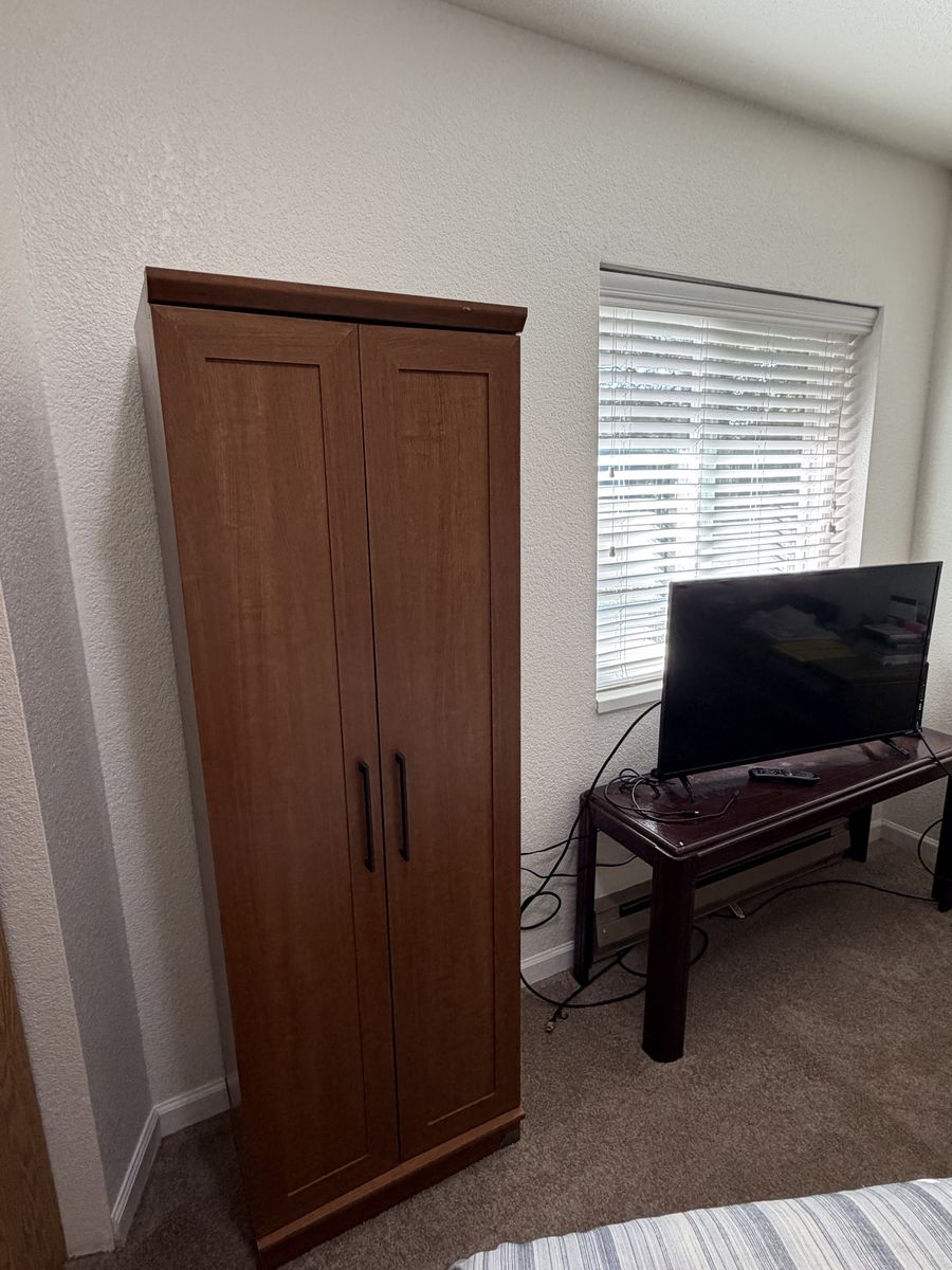Tall Wooden Storage Cabinet with Double Doors and Shelves and a short brown bookcase