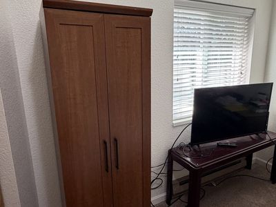 Tall Wooden Storage Cabinet with Double Doors and Shelves and a short brown bookcase