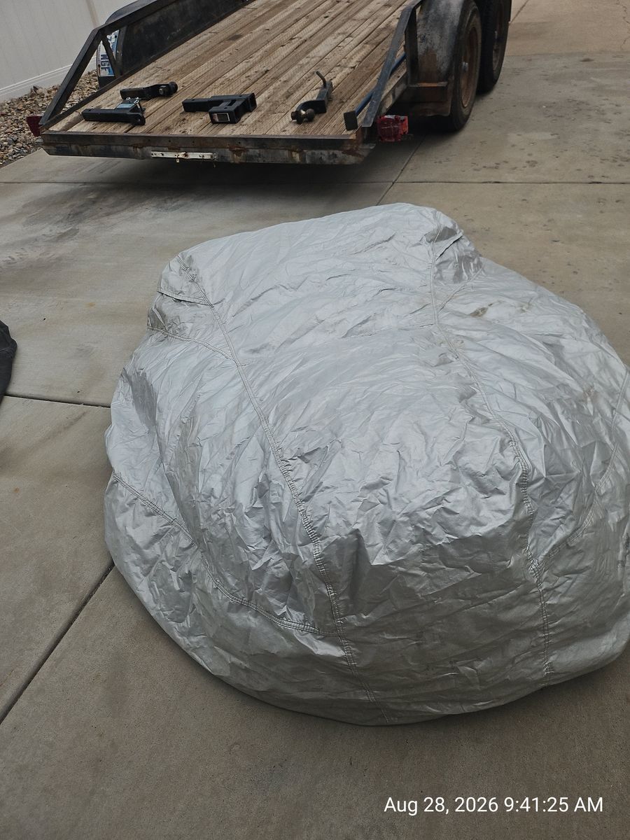 Large silver waterproof riding lawnmower or ATV cover with storage bag