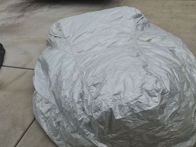 Large silver waterproof riding lawnmower or ATV cover with storage bag