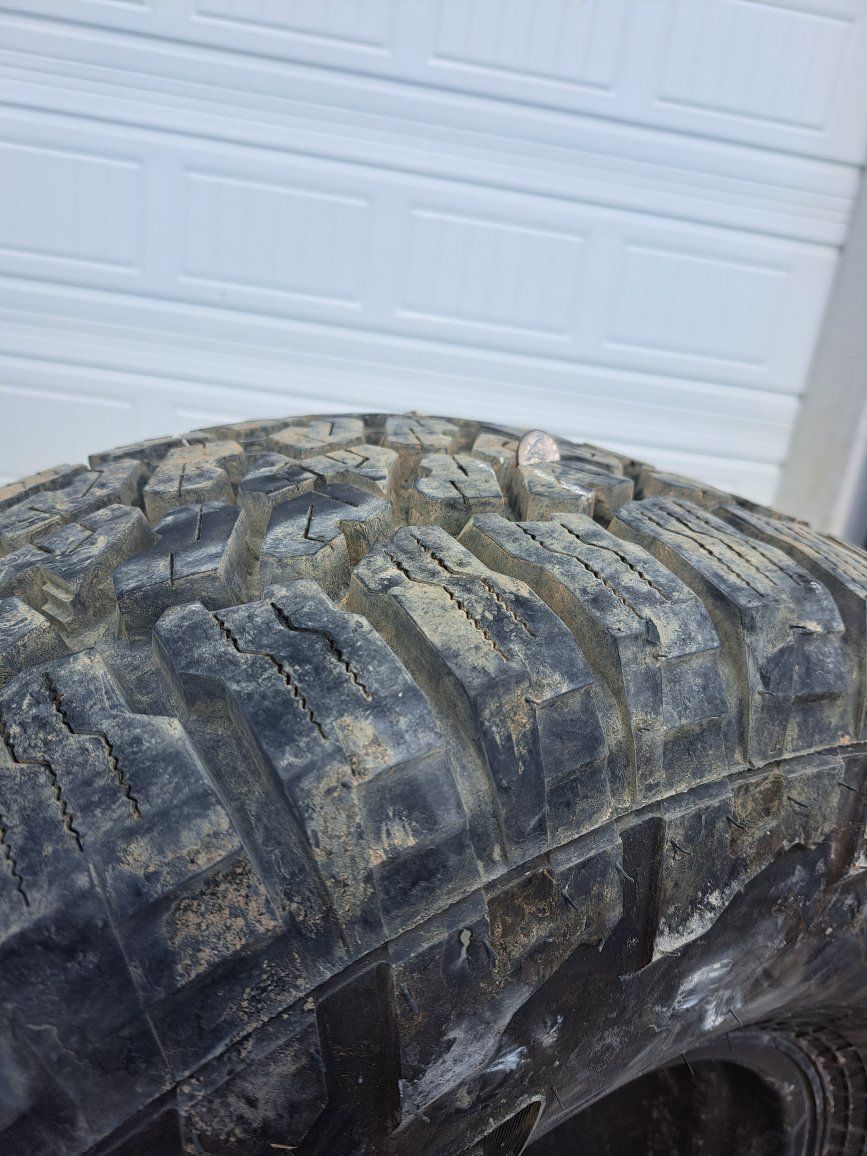 Used set of 4 33x12.50R15LT Mud-Terrain Tires with Black Steel Wheels