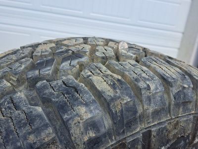 Used set of 4 33x12.50R15LT Mud-Terrain Tires with Black Steel Wheels