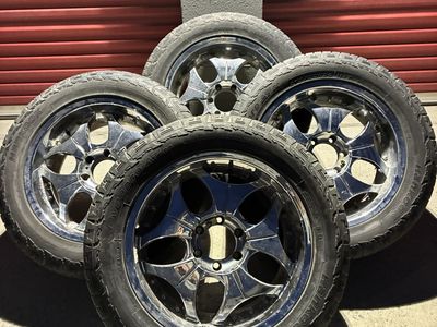 Set of 4 chrome wheels with tires mounted.