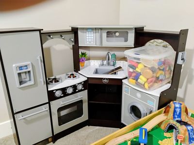 Play kitchen with toy food, plates, pans