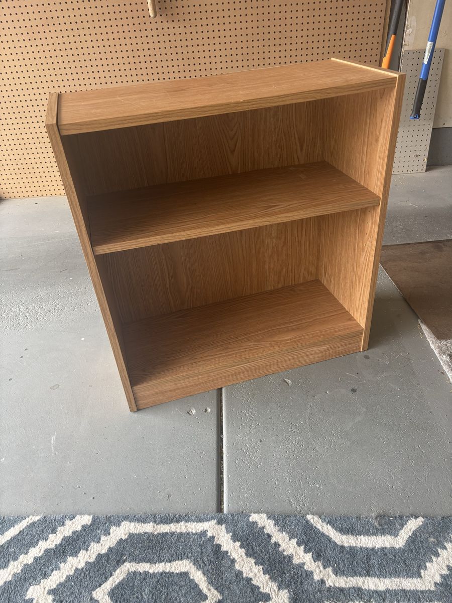 Small light brown bookcase with shelf