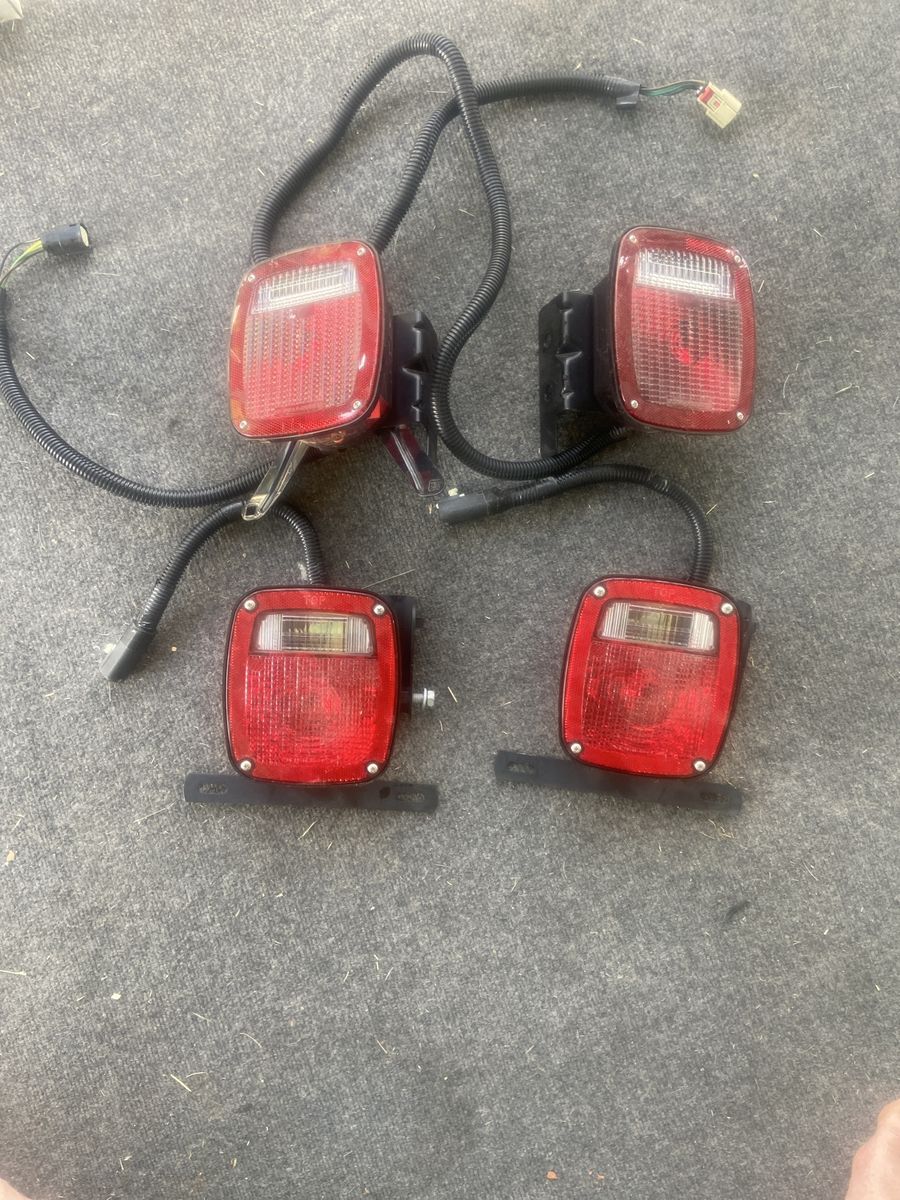 Set of 4 Red Trailer Taillights with Wiring Harnesses and Mounting Brackets.