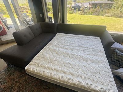 Large grey couch which can also fold out into a queen mattress