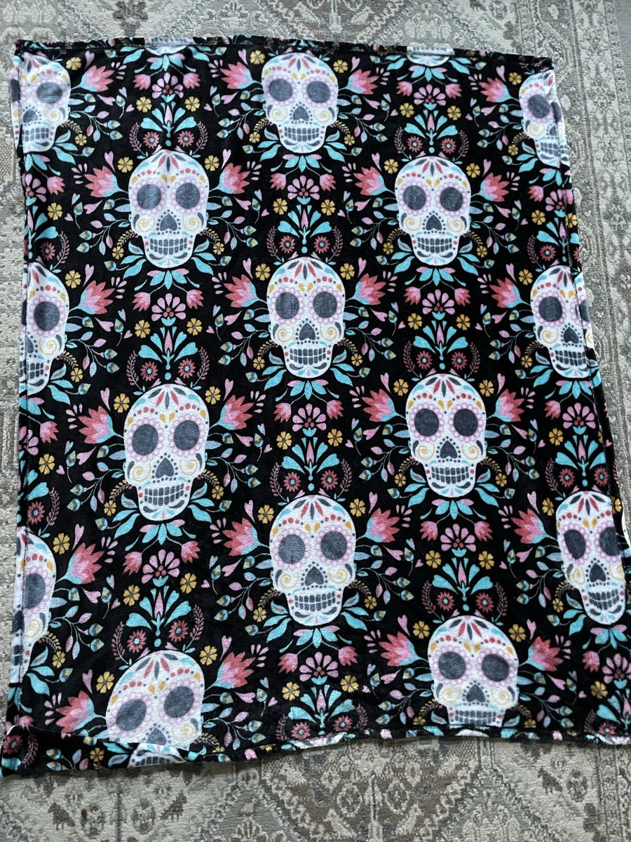 soft throw blanket features a vibrant, repeating pattern of colorful Day of the Dead