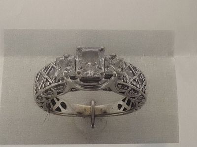 Vintage-inspired three-stone cathedral diamond engagement ring.