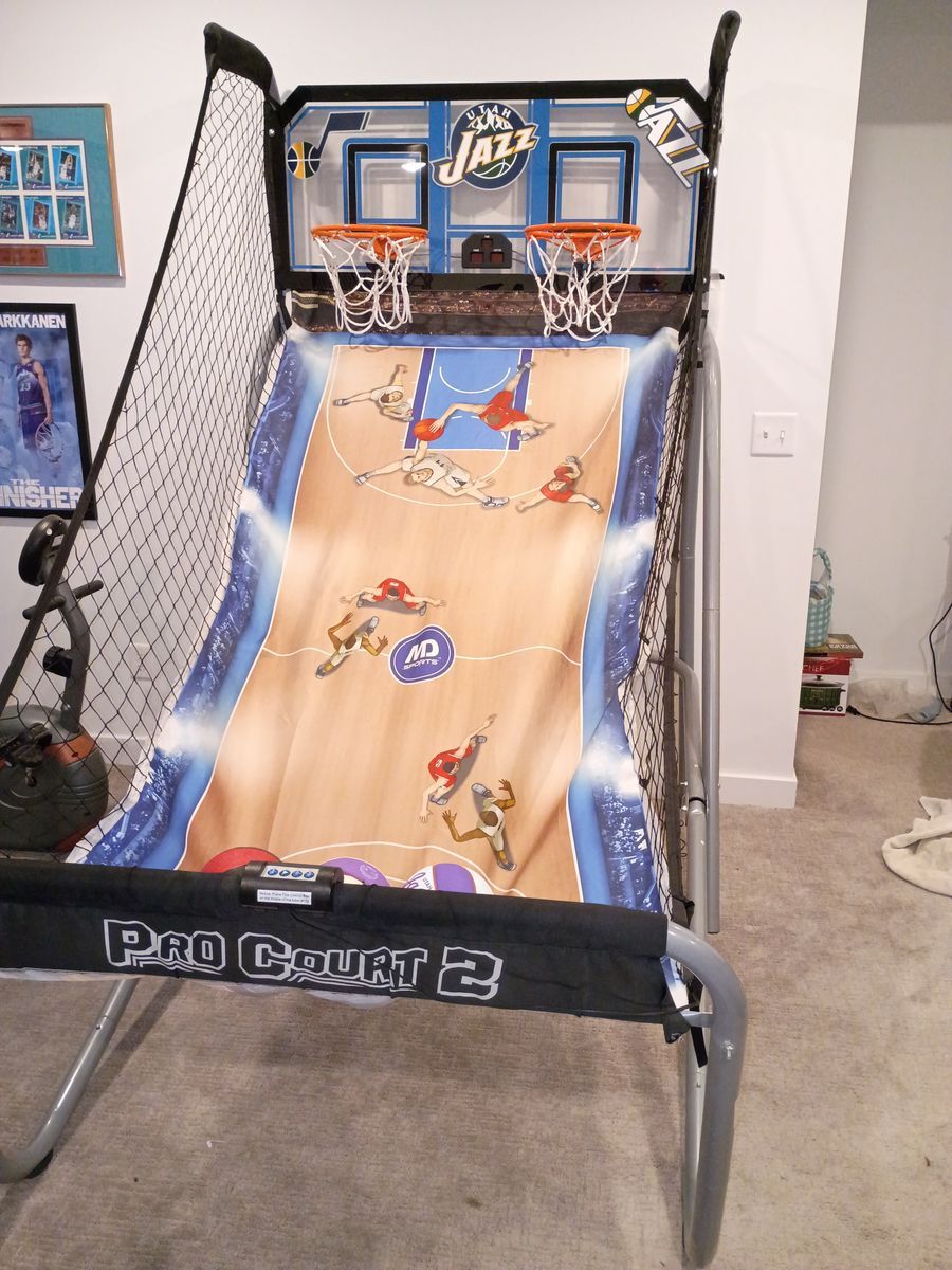 Arcade basketball game with electronic scoreboard, Utah Jazz graphics and basketballs