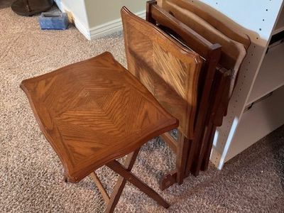folding wooden TV trays (snack tables)—likely 1970s–1990s oak or oak-veneer sets.