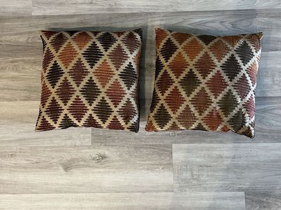 Two large 20 x 20 pillows in the colors of orange, brown and tan.