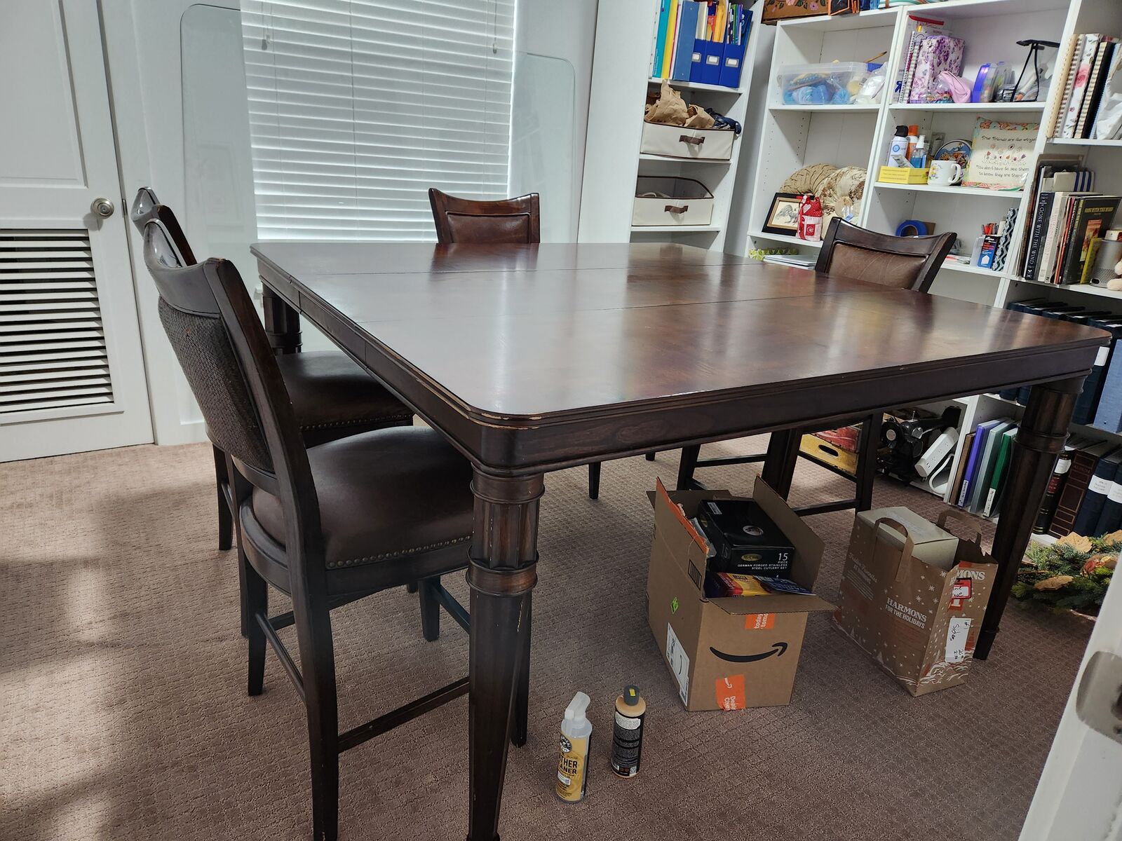 Solid wood dining table with leather chairs.
