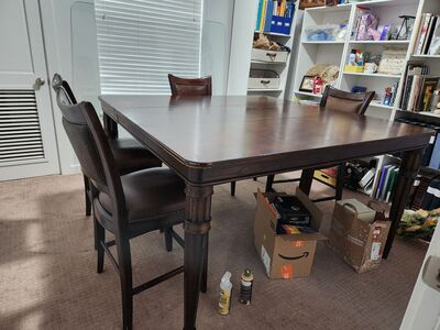 Solid wood dining table with leather chairs.