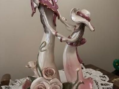 a Lladró. It is a piece from Blue Sky Clayworks, specifically a retired ceramic figurine titled "Lady Dancing with Child"