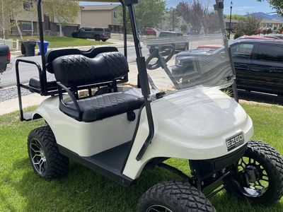 EZGO White Lifted Golf Cart with Custom Wheels & Rear Flip Seat