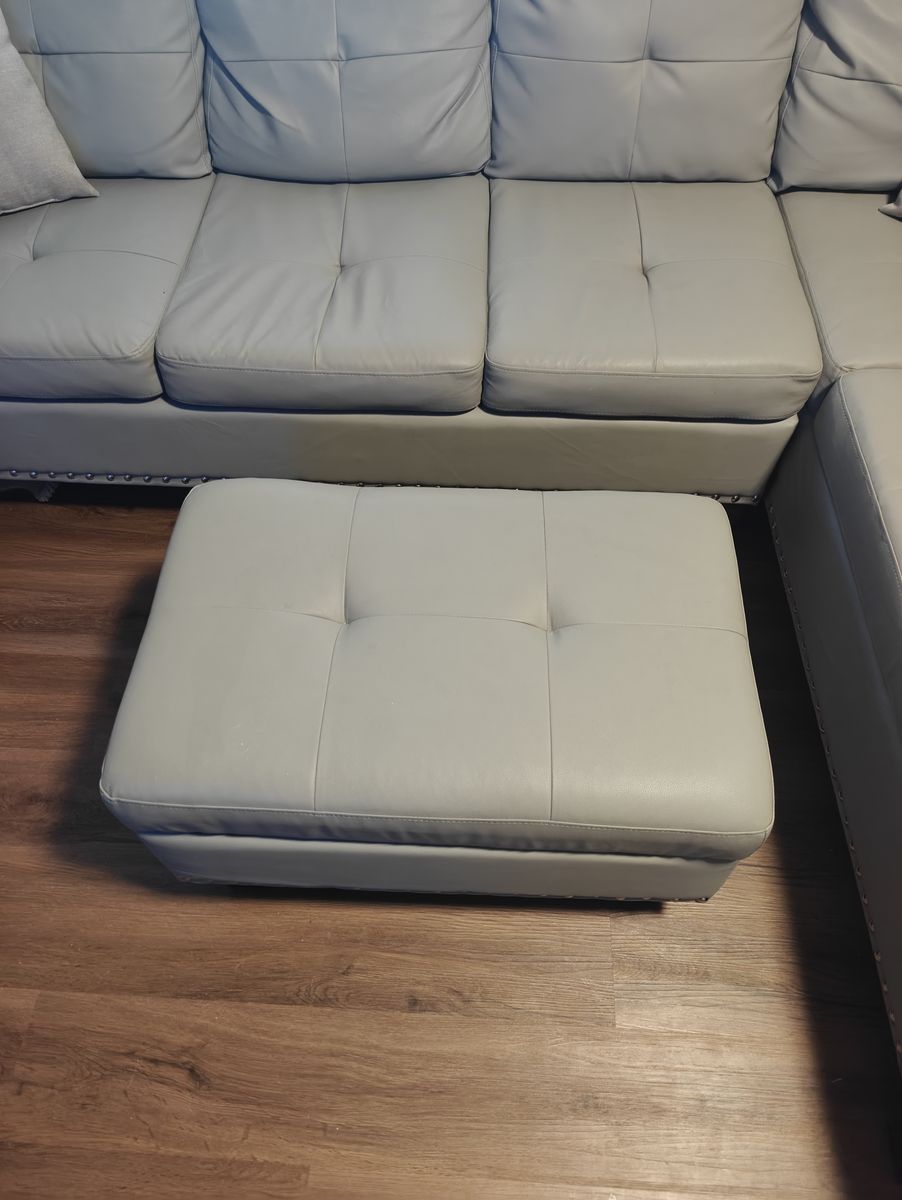 L-Shaped grey faux leather couch with ottoman